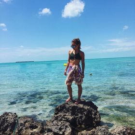 Woman standing on rocks in front of Secret Beach, Ambergris Caye, Belize – Best Places In The World To Retire – International Living
