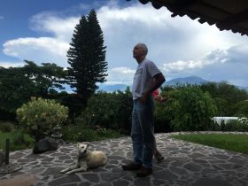 Chuck Bolotin standing outside home in Jocotepec, with Garcia and lake in distance – Best Places In The World To Retire – International Living