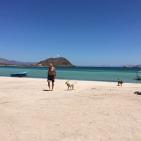 Man and dogs at Playa Santispac, Baja California – Best Places In The World To Retire – International Living