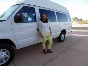 Jet Metier with her boots by a big white van, traveling to Mexico